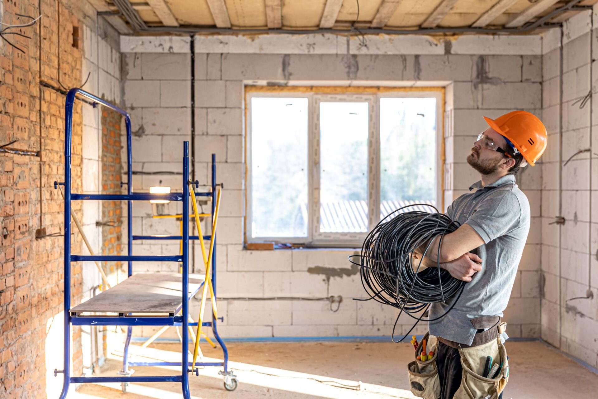 Electrician contractor looking unhappy holding roll of cables